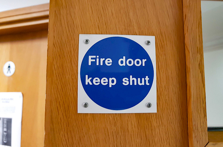 door with fire door keep shut blue sign